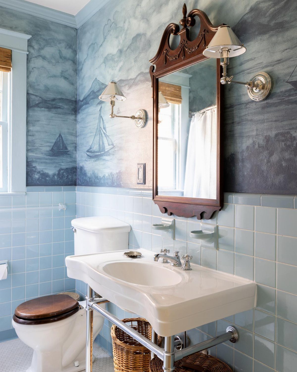 9 Bathroom Mural Ideas for Every Style and Space 2 Bathroom with a blue mural of sailboats and clouds above light blue tiles.