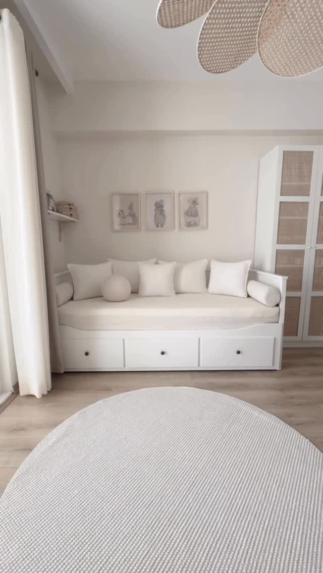 White daybed with pillows and storage drawers in a bright, minimalist living room