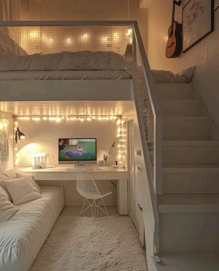 White loft bed with a cozy seating area and desk workspace underneath.