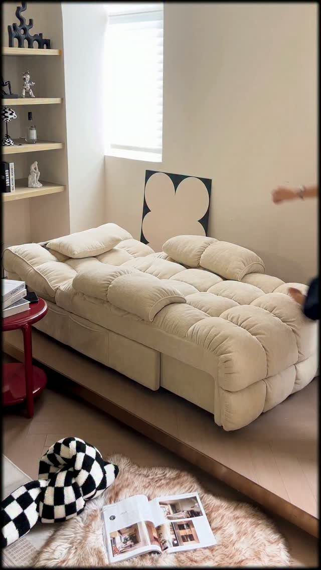Cream tufted floor mattress on a wooden platform in a minimalist living room